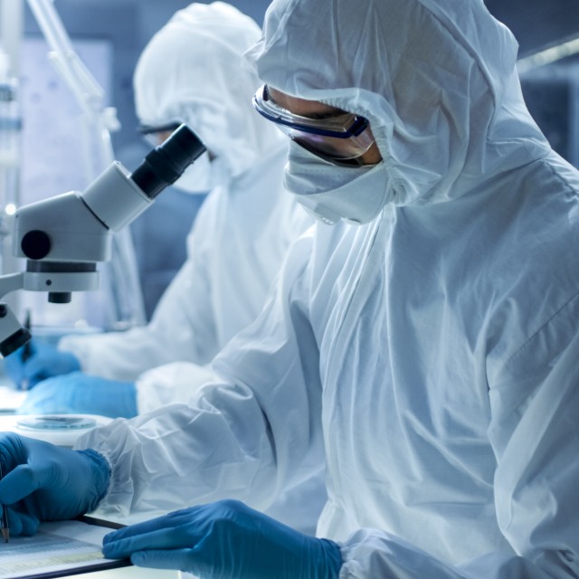 Scientists wearing protective suits in the lab