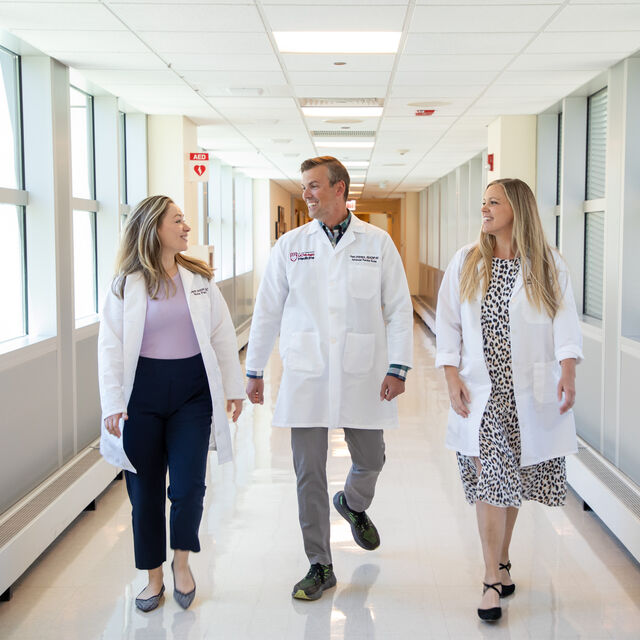 Photo of 3 APPs walking down a hallway