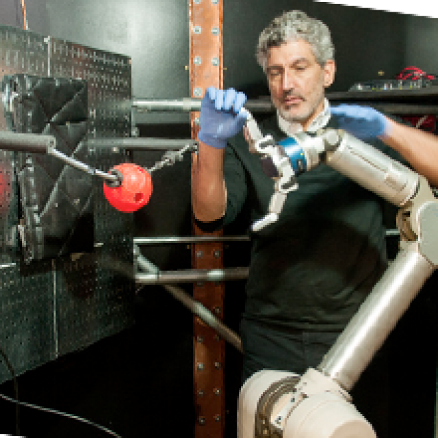 A researcher adjusts a robot arm
