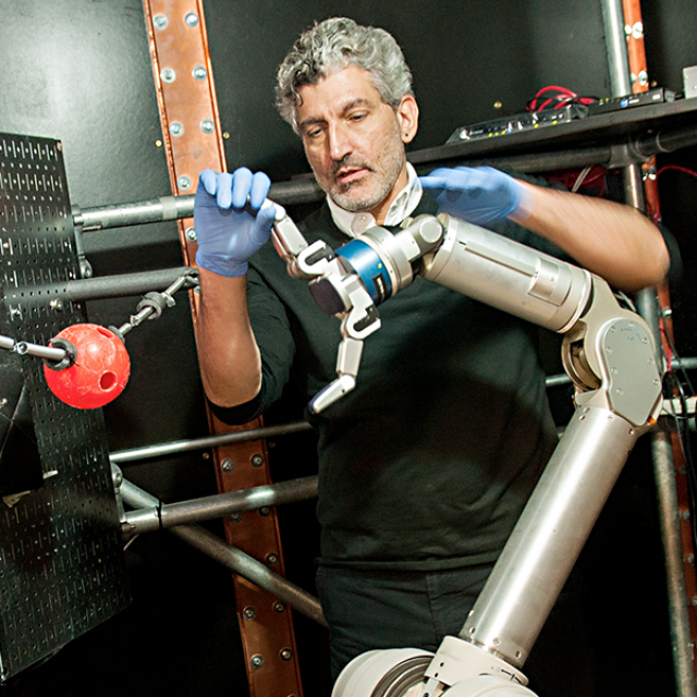 Faculty member working on a robotic arm